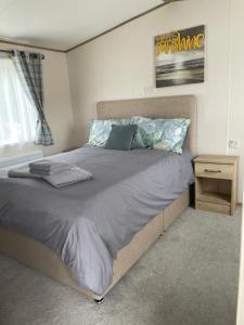 een slaapkamer met een groot bed en een nachtkastje bij Emma's Pad at Hoburne Naish - New Forest - Wheel chair Accessible with wetroom and ramp in Highcliffe