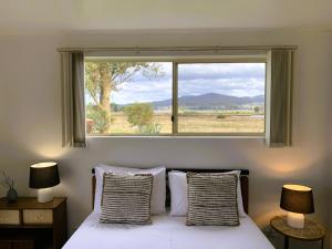 a bedroom with a bed and a large window at Pelican Point Park in St Helens