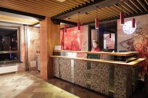 a man standing behind a counter in a restaurant at Hotel Nine Ulaanbaatar in Ulaanbaatar