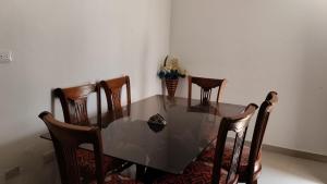 una mesa de comedor con sillas y un jarrón de flores en Aparta estudio - paris, en Ciénaga