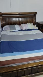 Cama con sábanas y almohadas azules y blancas en Aparta estudio - paris, en Ciénaga