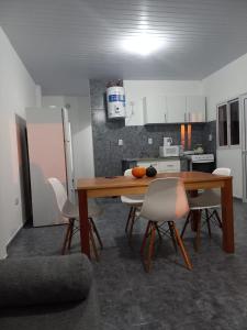 a kitchen with a wooden table and white chairs at Portal del Rio in Formosa