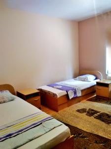 a room with two beds and two tables in it at Apartman ASI in Mostar