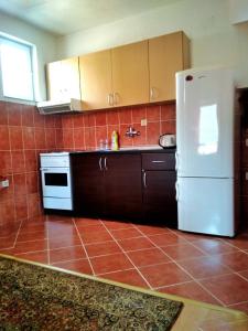 a kitchen with a white refrigerator and a tile floor at Apartman ASI in Mostar