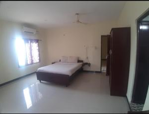 a bedroom with a bed in a room with a window at Shree SaiRenu near maruthamalai and bharathiyar univ and on the way to Adiyogi Isha Yoga centre in Marudhamalai