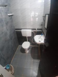 a small bathroom with a toilet and a sink at Shree SaiRenu near maruthamalai and bharathiyar univ and on the way to Adiyogi Isha Yoga centre in Marudhamalai