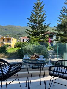 a table with a bowl of food on a balcony with two chairs at Maison deluxe studios and apartment in Parga