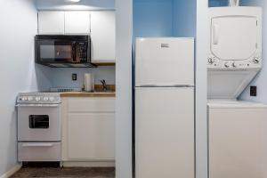 una cucina con armadietti bianchi e frigorifero di Beautiful Lake View Studio Condo at The Shores a Traverse City