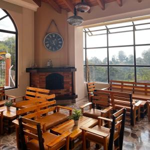 a restaurant with wooden tables and chairs and a clock on the wall at Hotel Casa Confort in Santa Rosa de Cabal