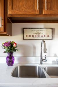- un évier de cuisine avec un vase violet et des fleurs dans l'établissement Beautiful 2BDR Loft Suite at Golf Course Condo 5549, à Traverse City