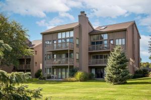 an exterior view of a large apartment building with a yard at Beautiful 2BDR Loft Suite at Golf Course Condo 5549 in Traverse City