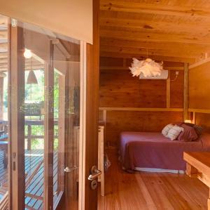 a bedroom with a bed in a wooden house at Eco Cabaña Río con Pileta privada in Tigre