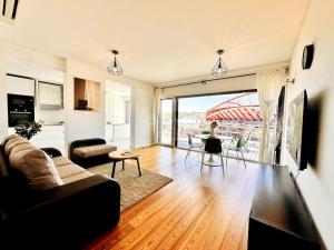 Luz Benfica Apartment في لشبونة: غرفة معيشة مع أريكة وطاولة