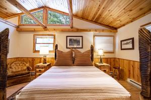 グレイリングにあるTimeless Charm 3BDR Whirlpool River Lodge 534の木製の天井の客室で、ベッドルーム1室(大型ベッド1台付)