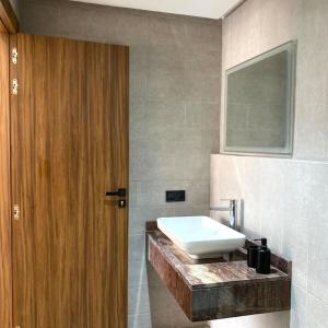 een badkamer met een wastafel en een houten deur bij 2 bed apartment with Rooftop pool & gym downtown marrakech in Marrakesh