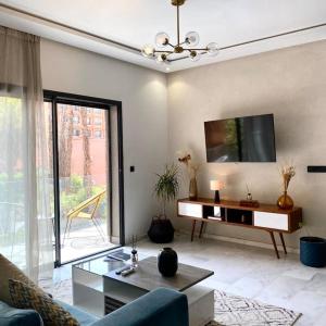 een woonkamer met een bank en een tv bij 2 bed apartment with Rooftop pool & gym downtown marrakech in Marrakesh