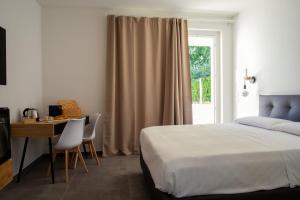 Schlafzimmer mit einem Bett, einem Schreibtisch und einem Fenster in der Unterkunft Ulivo Bianco in San Giovanni Teatino