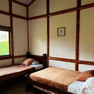 um quarto com duas camas e uma janela em Hotel Casa Confort em Santa Rosa de Cabal