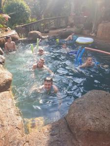 un grupo de niños jugando en una piscina en Canyon guest villa, en Hoedspruit