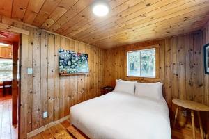 a bedroom with a bed in a wooden cabin at Fiddlers Green Cottage Two in Wasaga Beach +21 photos