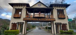 - un bâtiment avec un balcon et un panneau sur celui-ci dans l'établissement In the heart of Vilcabamba. Residence don Tuquito., à Vilcabamba