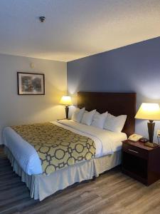a large bed in a hotel room with two lamps at Winston Salem Inn & Suites in Winston-Salem
