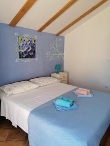 una camera da letto con un letto e asciugamani di Apartment Kukljica 8209a a Kukljica (Cuclizza)