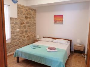ein Schlafzimmer mit einem Bett und einer Steinmauer in der Unterkunft Apartments by the sea Kukljica, Ugljan - 8209 in Kukljica