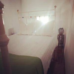 a bedroom with a white bed and a window at o Roxo in Castelo de Vide