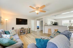 a living room with two couches and a ceiling fan at Coastal Emerald Isle Retreat with Deck and Grill! in Emerald Isle
