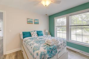 a bedroom with a bed and two windows at Coastal Emerald Isle Retreat with Deck and Grill! in Emerald Isle