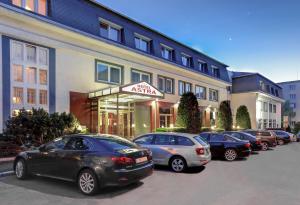 una fila di auto parcheggiate davanti a un edificio di Hotel Astra a Praga
