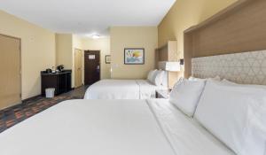 ein Hotelzimmer mit 2 Betten mit weißer Bettwäsche in der Unterkunft Holiday Inn Hotel & Suites Waco Northwest, an IHG Hotel in Bellmead