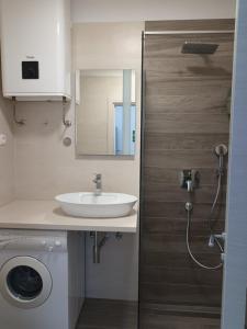 a bathroom with a sink and a washing machine at Apartments with a parking space Njivice, Krk - 14932 in Njivice