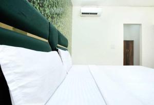 een slaapkamer met een bed met een groen hoofdeinde bij OYO Hotel Golden Crown in Rājpura