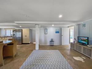 an empty living room with a television and a table at The Shack in Sarina