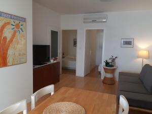 sala de estar con sofá y TV en Apartments by the sea Rastici, Ciovo - 4818 en Trogir