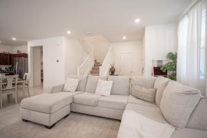 a white living room with a couch and a table at Beautiful Brand New 2 Bedroom Vegas Home! Fits 12 or more,15-20 minutes from LV Strip in Las Vegas