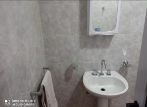 y baño con lavabo y espejo. en Departamento Chacra en Villa Regina