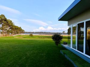 a house with a large yard with a view of the ocean at Pelican Point Tasmania in St Helens