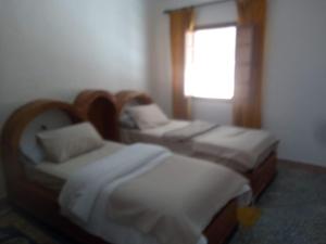 two beds in a room with a window at Amsa aqua villa in Tetouan