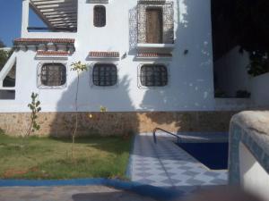 - un bâtiment blanc avec des fenêtres sur le côté dans l'établissement Amsa aqua villa, à Tetouan