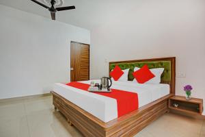 a bedroom with a large white bed with red pillows at Flagship Hotel Hc Punjab Inn in Mohali
