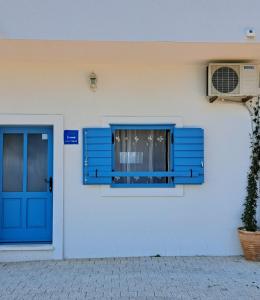 una puerta azul y una ventana en un edificio blanco en Seaside holiday house Igrane, Makarska - 21577 en Igrane