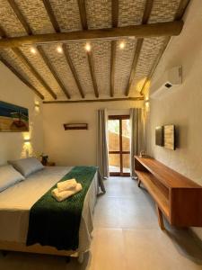 1 dormitorio con cama y mesa de madera en CasaMí en Ilhabela