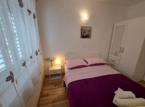 1 dormitorio con cama con sábanas rosas y ventana en Seaside holiday house Igrane, Makarska - 21577, en Igrane