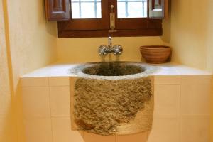baño con lavabo de piedra y ventana en Casa Rural el Recuerdo, en Pago de San Clemente