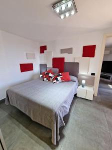 een slaapkamer met een groot bed met rode kussens bij Le 4 stagioni, appartamento in Villa in Bordighera