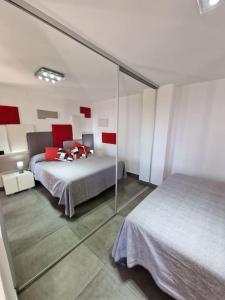 een slaapkamer met 2 bedden en een spiegel bij Le 4 stagioni, appartamento in Villa in Bordighera