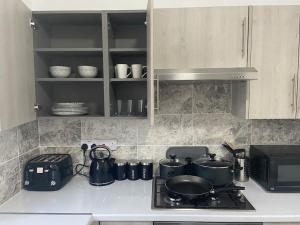 a kitchen with a stove with pots and pans on it at 2 Bedroom Flat in London in London